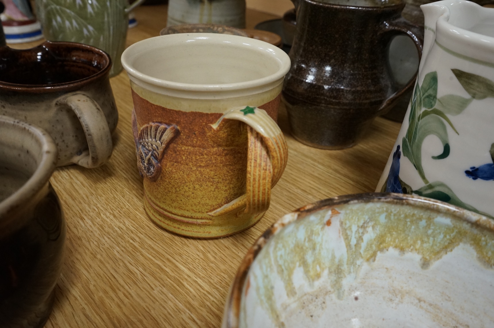 A large collection of studio pottery mugs bowls and jugs, tallest jug 21cm.